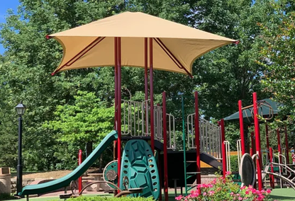 Playground with a large umbrella overhead casting shade